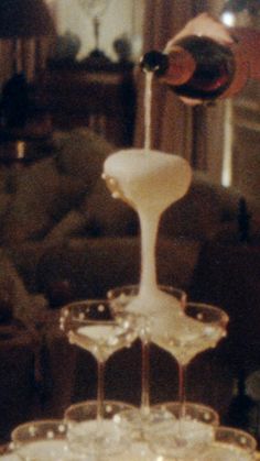 two wine glasses are stacked on top of each other in front of a couch and coffee table