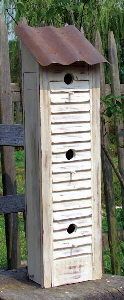 a bird house sitting on top of a wooden bench