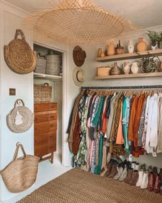 a closet filled with lots of different types of clothes and baskets hanging from the ceiling