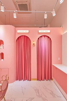 a room with pink curtains and chairs in it