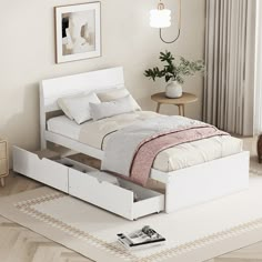 a white bed with drawers underneath it in a room next to a table and chair