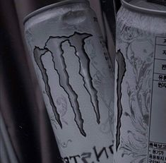 two cans of monster energy drink with chinese writing on the front and back covers,