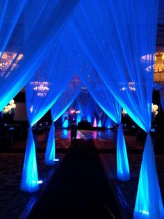 an indoor event with blue lights and drapes