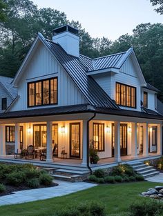 a large white house with lots of windows on the front and side of it at night