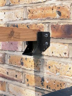 a skateboard resting on the edge of a brick wall next to a wooden rail