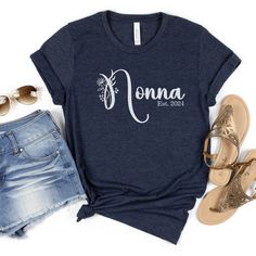 a women's t - shirt with the word donna printed on it, next to denim shorts and sandals