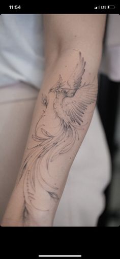 a woman's arm with a bird tattoo on it