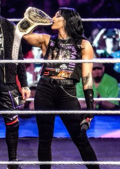 the woman is kissing the man's face in front of him on the wrestling ring