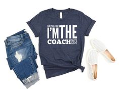 a t - shirt that says i'm the coach next to some ripped jeans