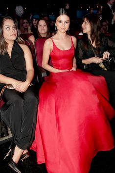 two women in red dresses sitting next to each other