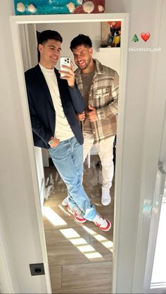 two young men taking a selfie in the mirror while standing next to each other