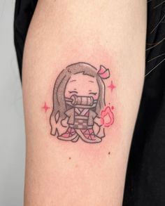 a small cartoon character tattoo on the right upper half of the arm, with pink stars around it