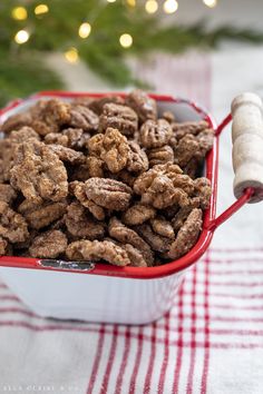 a red and white container filled with nuts on top of a checkered table cloth