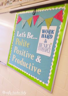 a bulletin board hanging on the wall in a school classroom with words and bunting