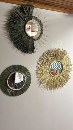 three circular mirrors mounted on the wall above each other, one with a decorative design