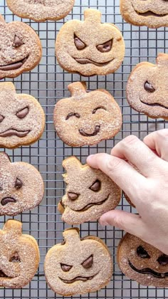 there is a hand that is picking up some cookies with smiley faces on the cookie sheet