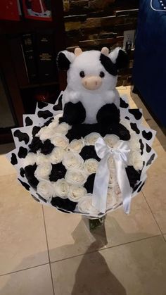 a teddy bear sitting on top of a cake covered in white and black frosting