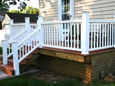 a porch with white railings and wooden steps