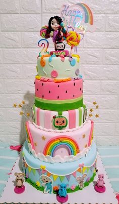 there is a multi layer cake decorated with animals and rainbows on the top tier