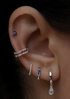 a woman's ear with three different types of piercings