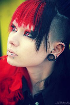 a woman with red hair and piercings on her ears