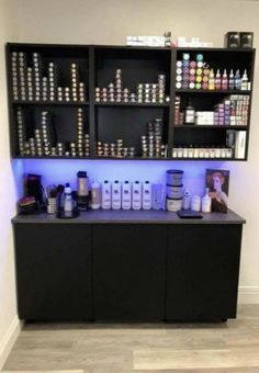 a counter with lots of bottles and containers on it in front of a white wall