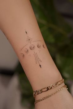 a woman's arm with an arrow and phases tattoo on the left side of her arm