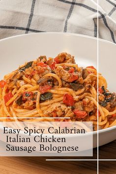 a white bowl filled with pasta and meat on top of a wooden table next to a fork