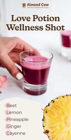 a woman is holding a glass with a drink in it and the words love potion wellness shot