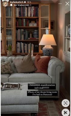 a living room filled with furniture and bookshelves next to a lamp on a table