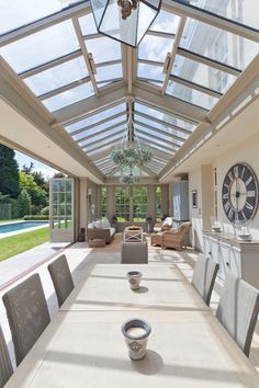 the inside of a house with glass roof and sunlit dining room area in it