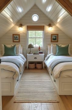 two beds in a room with white walls and wood flooring, along with a rug on the floor