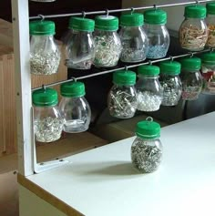 there are many glass jars on the shelf and one is filled with silver flakes