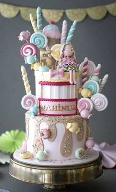 a pink and white cake with lots of candies on it's tiers