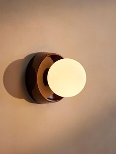 a light that is on the wall next to a brown and white object with a shadow