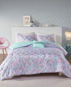 a bed with blue and pink comforters in a room