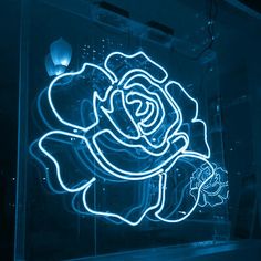 a neon rose on display in a dark room