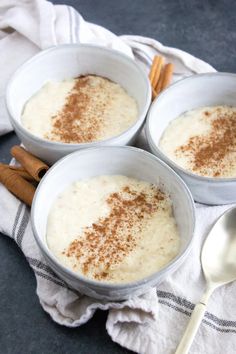 three bowls filled with oatmeal and cinnamon on top of a white towel