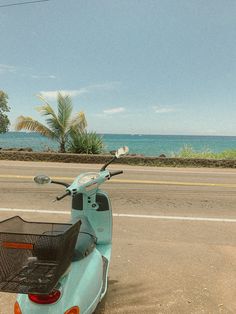 a scooter is parked on the side of the road next to the ocean