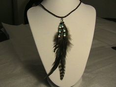 a white mannequin with a feather necklace on it