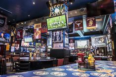 the inside of a sports bar with tables and chairs