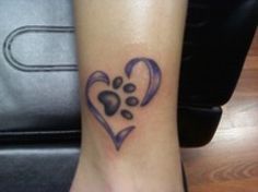 a dog's paw and heart tattoo on the left ankle is shown in purple ink