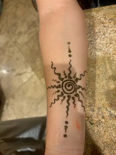 a woman's arm with a tattoo on it that looks like a sunflower