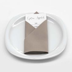 a white plate topped with a napkin and an envelope on it's end piece