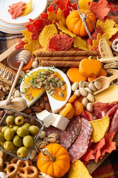 a platter filled with cheese, crackers, olives, nuts and other foods