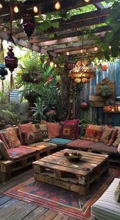 an outdoor living area with couches, tables and lights