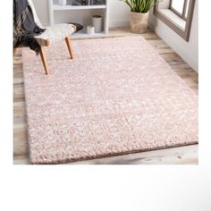 a pink rug in the corner of a room with a chair and potted plant