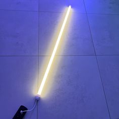 a light saber laying on the floor next to a remote control