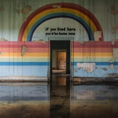 an empty room with a rainbow painted on the wall and a doorway leading into it