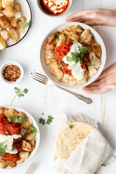 two plates of food on a table with utensils and napkins next to them